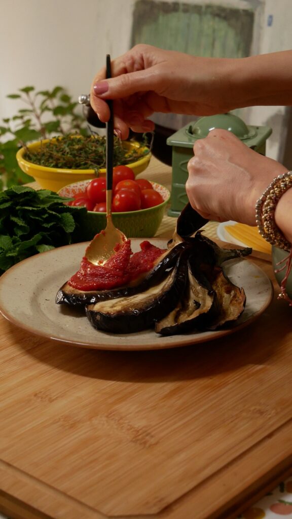 paso de la receta: poner tomate frito entre los cortes de la berenjena