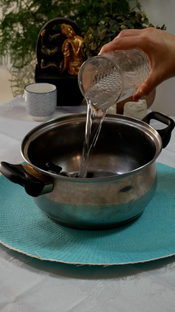 añadiendo agua a la olla para abrir los mejillones