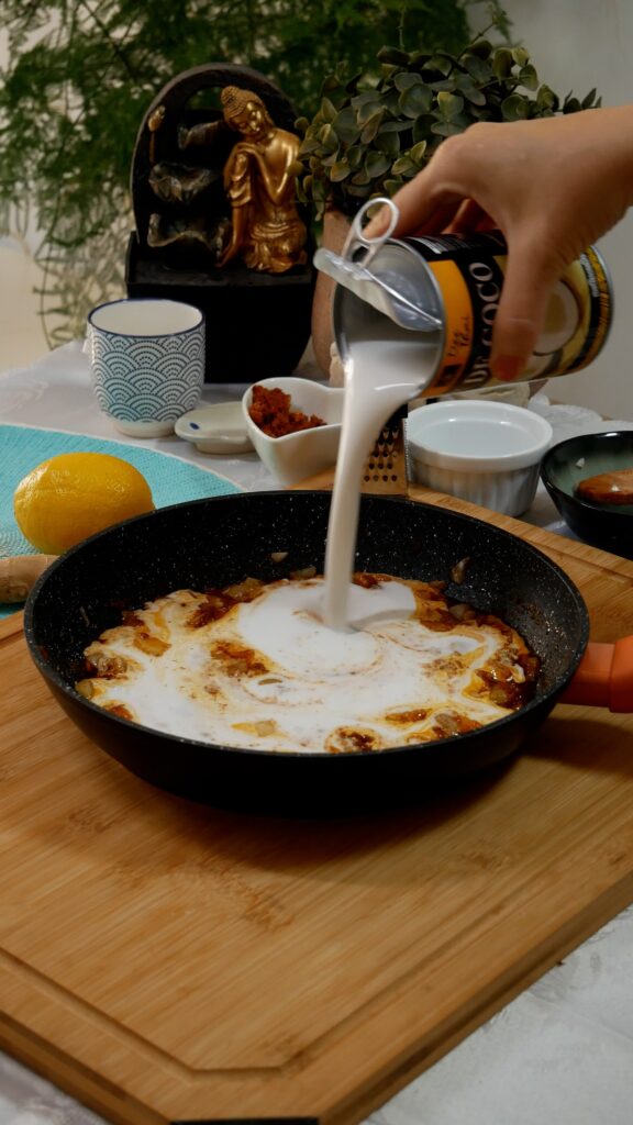 añadiendo leche de coco a la sartén